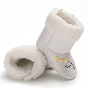 Gros plan sur bottes hiver bébé blanches doublées polaire avec nœud et motif renard