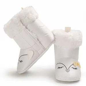 Détail de bottines d'hiver blanches pour bébé avec fourrure et broderie