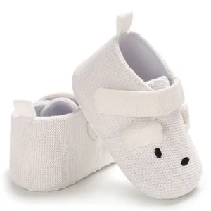 Detailaufnahme weißer gestrickter Lauflernschuhe für Babys mit Klettverschluss
