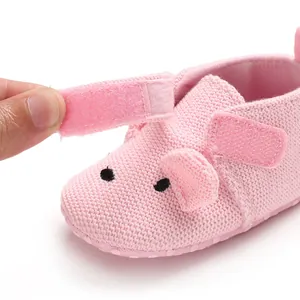 Nahaufnahme des Klettverschlusses an einem rosa gestrickten Baby-Lauflernschuh
