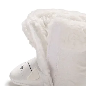 Gros plan de bottines d'hiver blanches pour bébé avec doublure douce et fermeture velcro