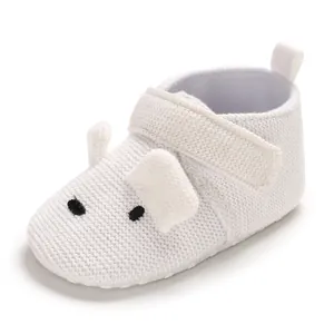 Nahaufnahme weißer gestrickter Babyschuhe mit süßem Tiergesicht und Klettverschluss