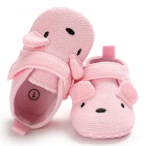 Nahaufnahme von rosa gestrickten Baby-Lauflernschuhen mit süßem Cartoon-Tiergesicht
