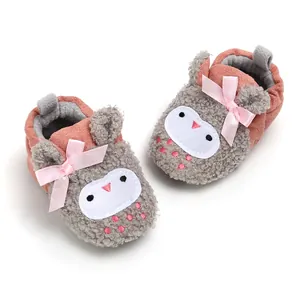 Close-up of cute owl cartoon baby winter booties with pink ribbon bows