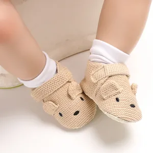 Detailansicht niedlicher gestrickter Lauflernschuhe für Babys mit Bärengesicht und weicher Sohle