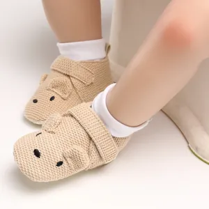 Nahaufnahme von süßen gestrickten Babyschuhen mit Tiermotiv und weicher Sohle mit Klettverschluss