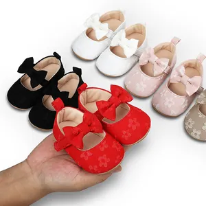 Primer plano de zapatos de princesa para bebé en encaje rojo con lazo y varios colores