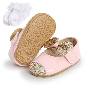 Detail of pink baby princess shoes with glitter bow and matching lace socks