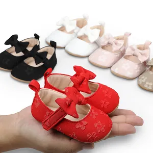 Primer plano de zapatos de princesa para bebé en encaje rojo con un lazo.