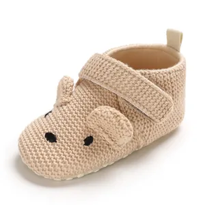 Nahaufnahme beige gestrickter Babyschuh mit süßem Bärengesicht und weicher Sohle