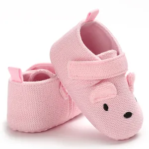 Detailaufnahme von rosa gestrickten Babyschuhen mit süßem Ohrendesign und weicher Sohle