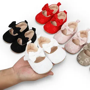 Primer plano de zapatos de princesa para bebé en encaje con bordado y lazo.