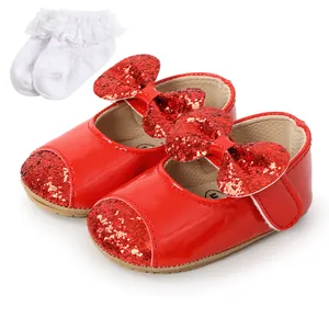Close-up detail of shiny red glitter baby Mary Jane shoes with white ruffled lace socks