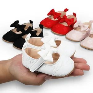 Detalle de zapatos de princesa de encaje blanco para bebé con lazo
