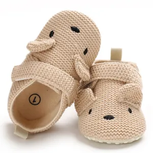 Detailansicht weicher beiger gestrickter Baby-Laufschuhe mit süßem Tierohr-Design