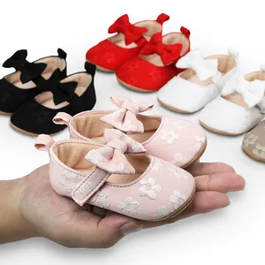 Primer plano de zapatos de princesa de encaje rosa para bebé con lazo y suela blanda