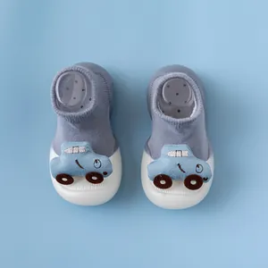 Detail der blauen Babysocken-Schuhe mit Auto-Ornament und rutschfester Gummisohle