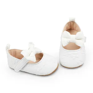 Detalle de zapatos de princesa para bebé de encaje blanco con lazo elegante