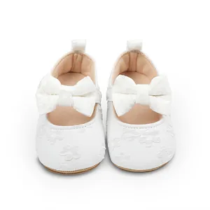 Vista detallada de zapatos de princesa de encaje blanco para bebé con lazos finos
