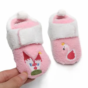 Detailopname van zachte roze pluche babyloopschoenen met borduursel van een zwaan.