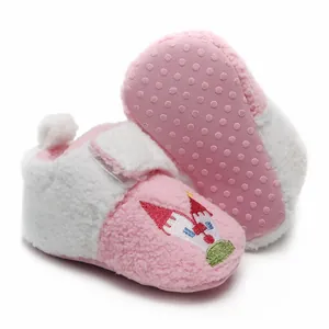 Detail van roze pluche baby-wandelschoenen met antislipzool en kasteelborduursel