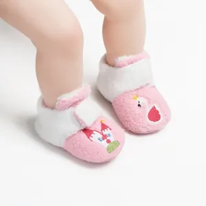 Detail van zachte roze pluche winterbabyschoentjes met zwaan en kasteel borduursel