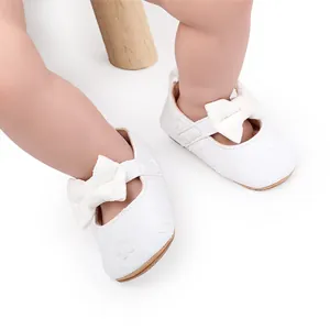 Primer plano detallado de zapatos de bebé en encaje blanco con lazo decorativo y bordado