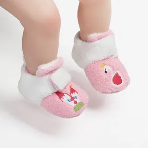 Close-up van roze pluche babyloopschoentjes met zwaan en kasteel borduurwerk