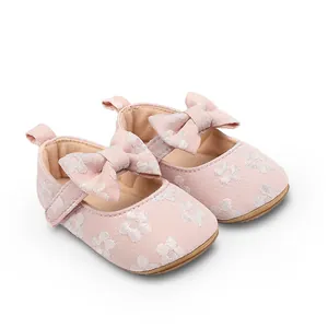 Vista detallada de zapatos de princesa rosas para bebé con flores y una gran decoración de lazo
