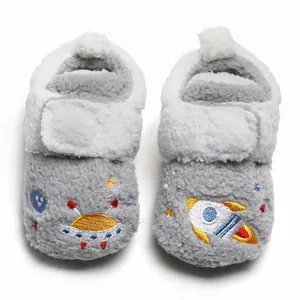 Detailweergave van winterse pluchen baby-loopschoentjes met schattige ruimteborduring