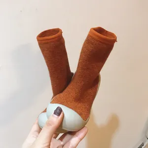 Détail de chaussures chaussettes bébé en maille orange avec semelle antidérapante
