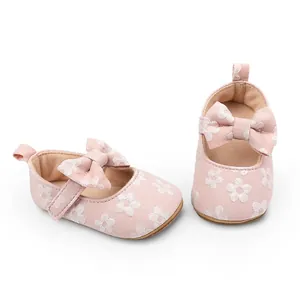 Detalle de zapatos de gateo rosas con flores y lazo para bebé niña