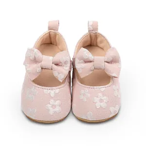 Vista detallada de zapatos de encaje floral rosa para bebé con lazo decorativo