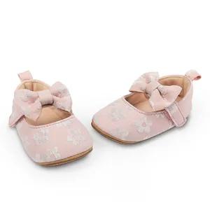 Vista detallada de zapatos de princesa rosa para bebé con diseño de flores y lazos.