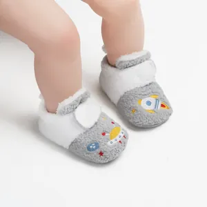 Close-up van pluizige baby loopschoentjes voor de winter met raketborduurwerk.