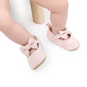 Primer plano de zapatos Mary Jane rosas para bebé con encaje floral y lazo.