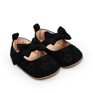 Detalle de zapatos de princesa para bebé niña en encaje negro con lazo elegante