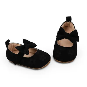 Vista detallada de zapatos negros para bebé niña con suela blanda y un lazo grande