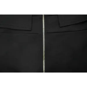 Close-up detail of the durable silver metal zipper on a black knitted evening dress.