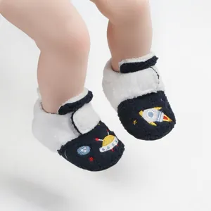 Gedetailleerd overzicht van pluche baby-winterschoentjes met geborduurd ruimtevaartthema