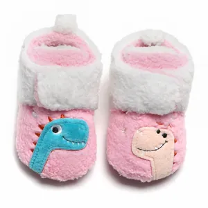 Detailopname van roze fleece babyslofjes met schattige cartoon dinosaurus borduursels