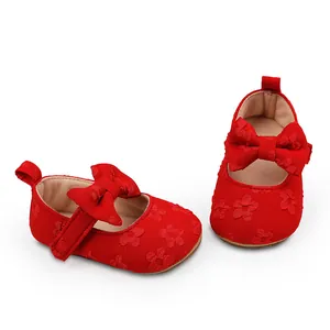 Detalle de zapatos de princesa para bebé en encaje rojo con un elegante lazo decorativo