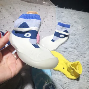 Detailansicht der rutschfesten Baby-Socken mit blauem Waschbärmuster und weicher Sohle.