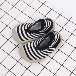 Breathable black and white striped baby walker shoes featuring a non-slip beige rubber sole