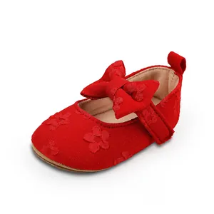 Vista detallada de zapatos de princesa para bebé en encaje rojo con un gran lazo