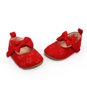 Detalle de zapatos de princesa para bebé en encaje rojo con lazo y flores bordadas