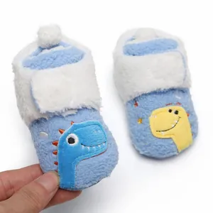 Close-up van zachte pluche baby-pre-walker schoenen met schattig dinosaurusborduurwerk.