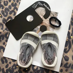 Nahaufnahme von karierten Socken-Schuhen für Kleinkinder mit flexibler Gummisohle für drinnen