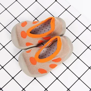 Detail view of breathable baby sock shoes with orange polka dots and anti-slip sole