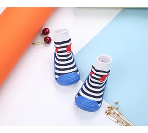 Close-up detail of blue striped baby sock shoes with non-slip soles and fish pattern.